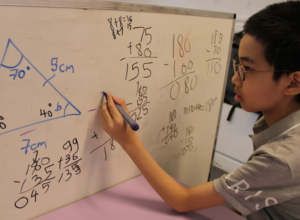 Student solving math equations on whiteboard